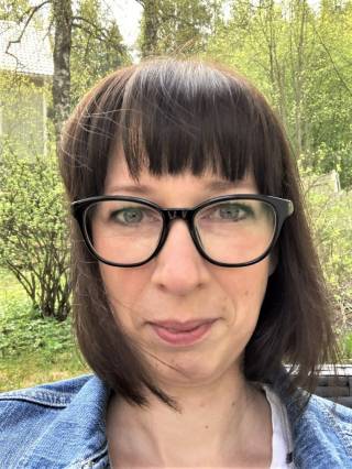 A woman with glasses and dark hair.