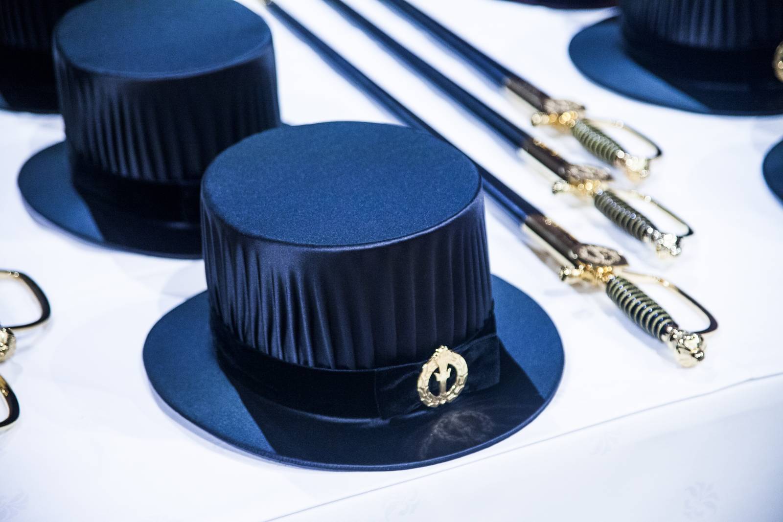 Siliter hats and swords on a white tablecloth for doctoral promotion