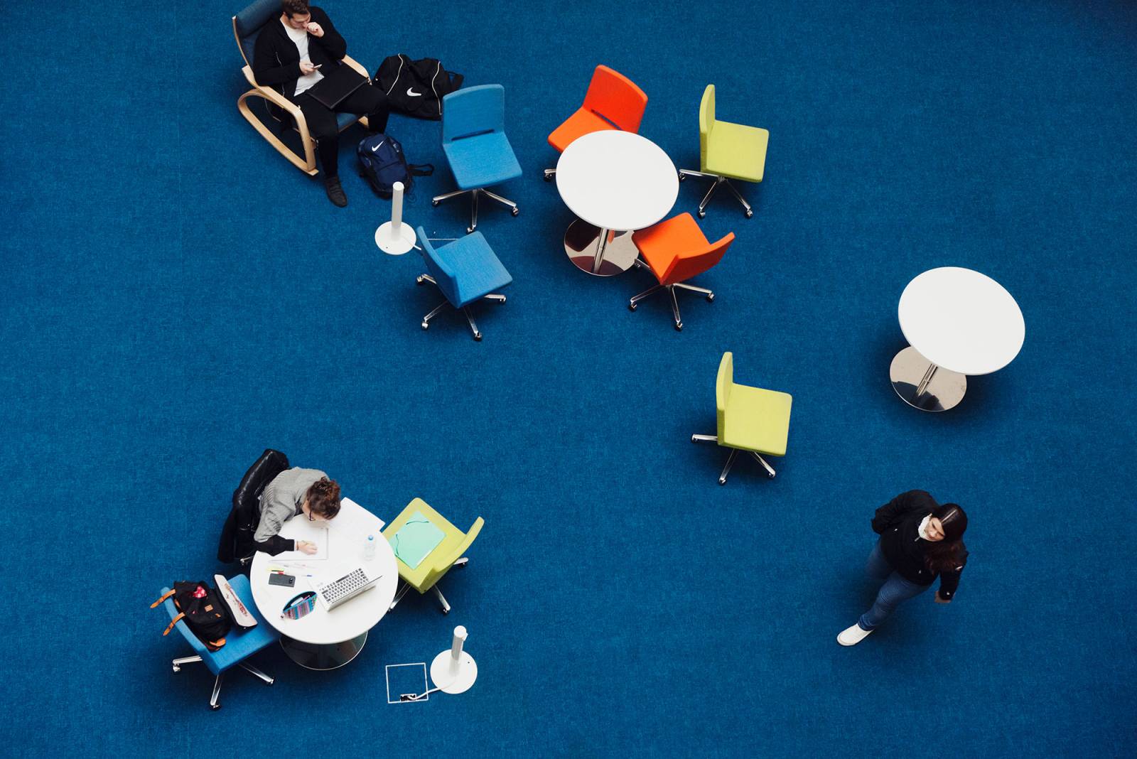 Tables and chairs on a dark blue floor.