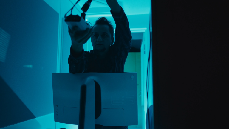 A man adjusting a video camera in a test booth.