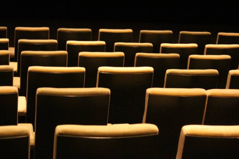 Keltaisia elokuvakatsomon istuimia kuvattuna takaapäin.