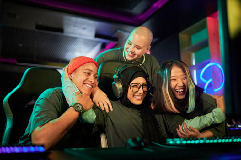 Diverse team of female gamers celebrating victory in cybersports competition and cheering