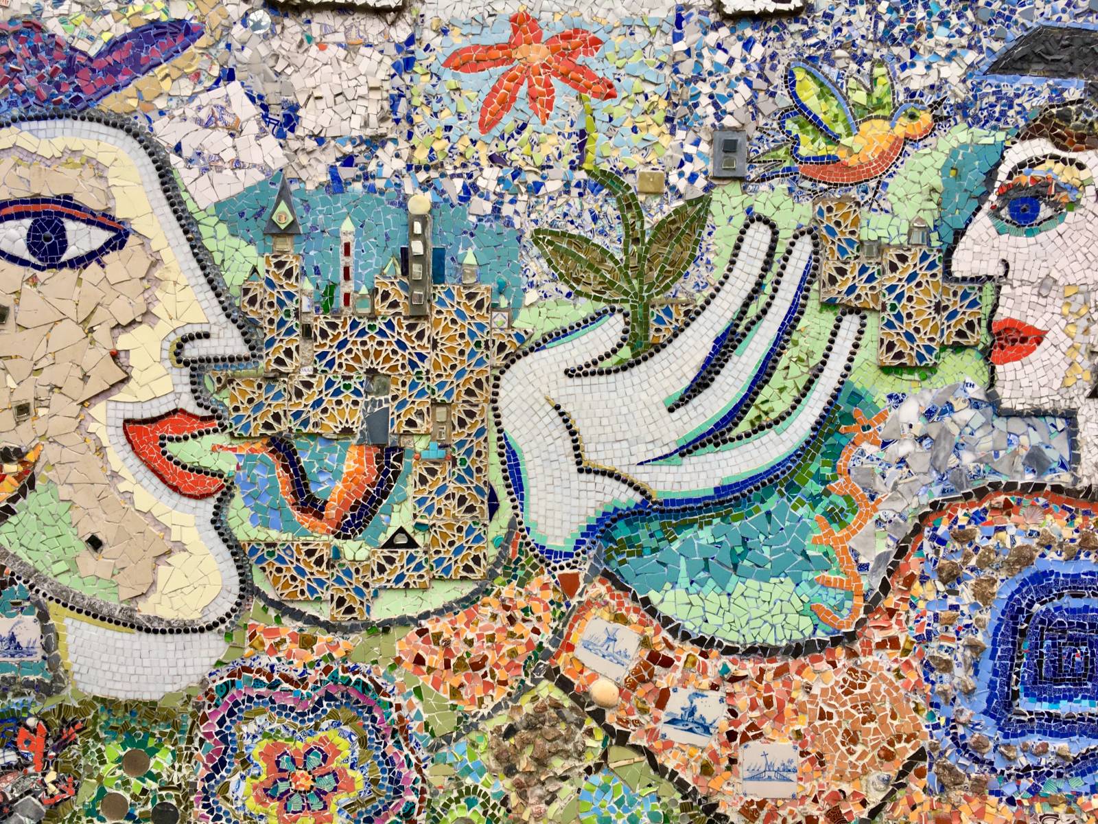 Mosaiikkiteos, jossa näkyy kaksi ihmistä. Vasemmalla oleva puhuu, oikealla oleva kuuntelee.
