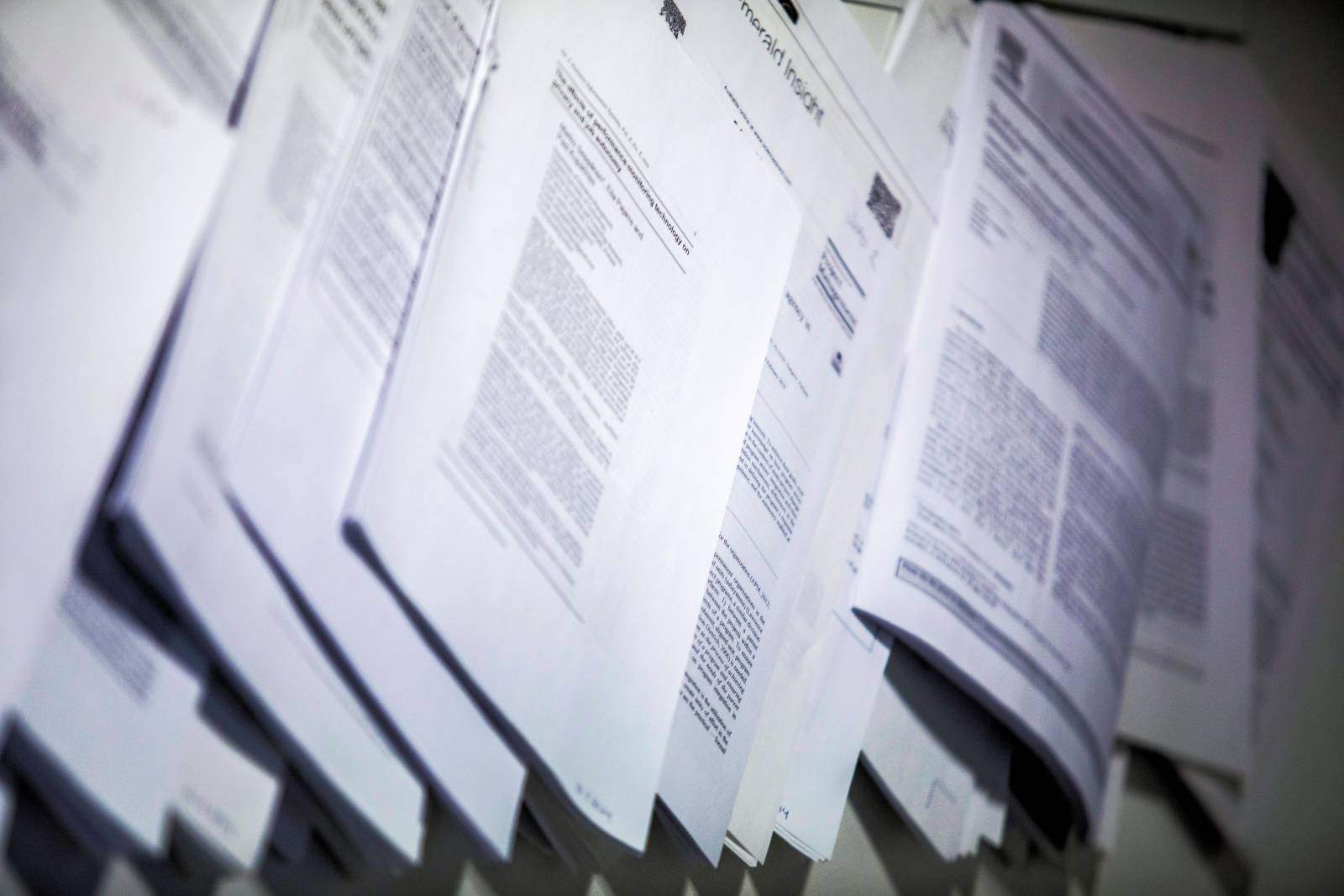 printed articles overlapped on a bulletin board
