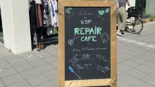 A sign with text in front of a repair cafe