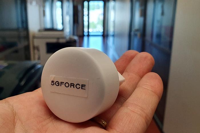 Picture of a small powerplug-like sensor on a hand with 5GFORCE text.