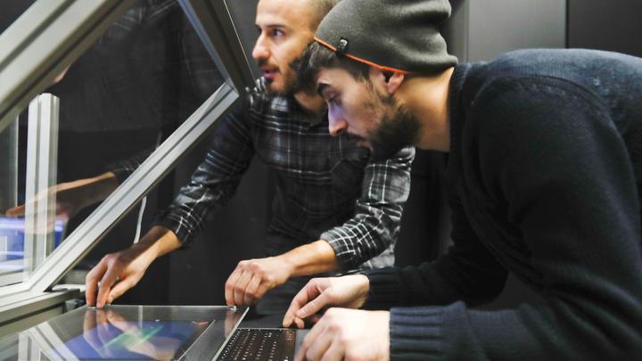 Two researchers working on a HUD display at CIVIT lab