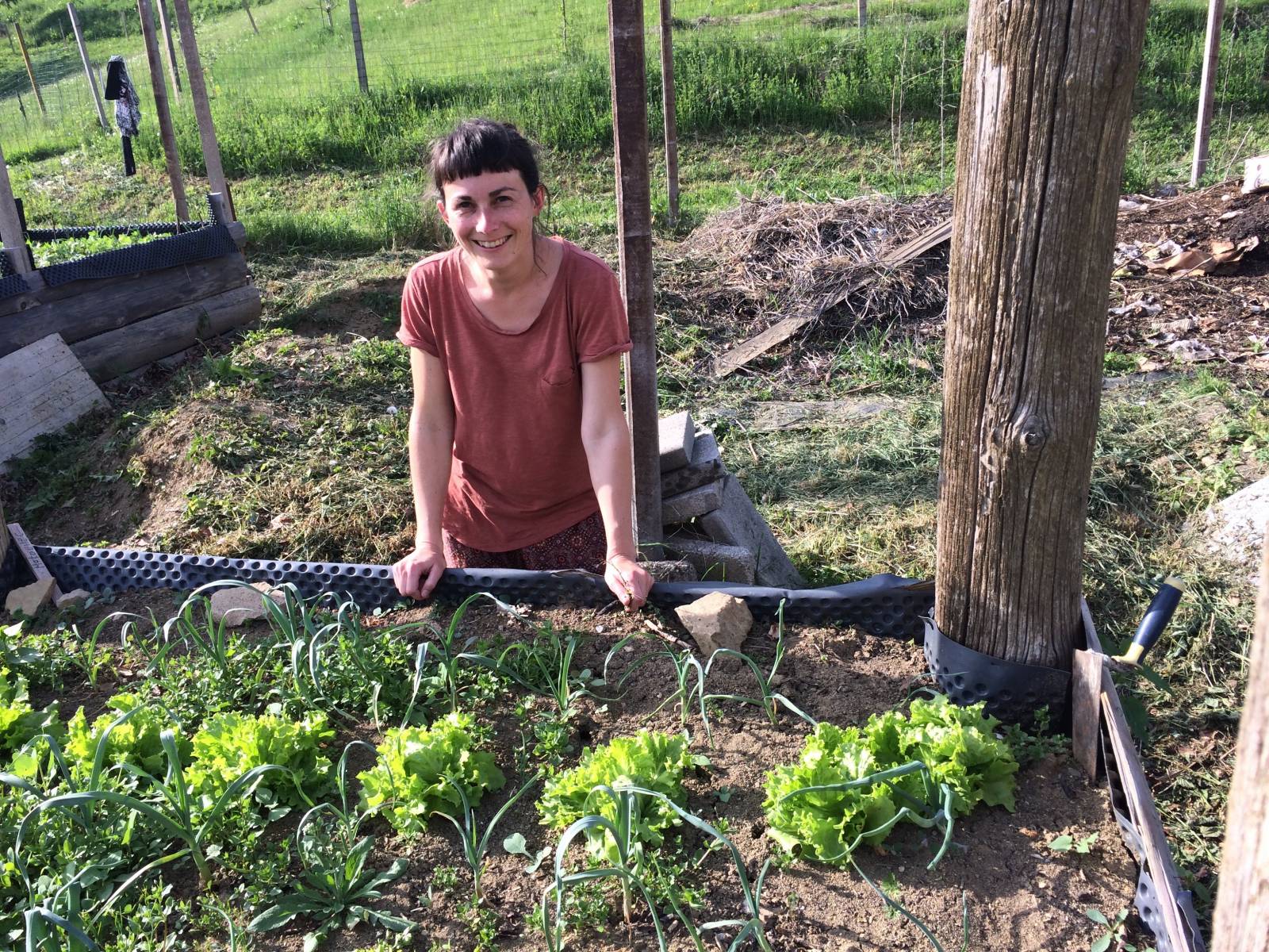 Smiling woman next to the flowerbed.