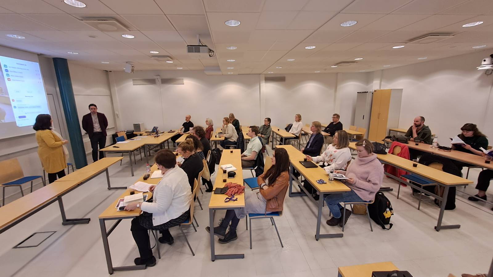 Ihmisiä istumassa luentosalissa kirjamessuilla.