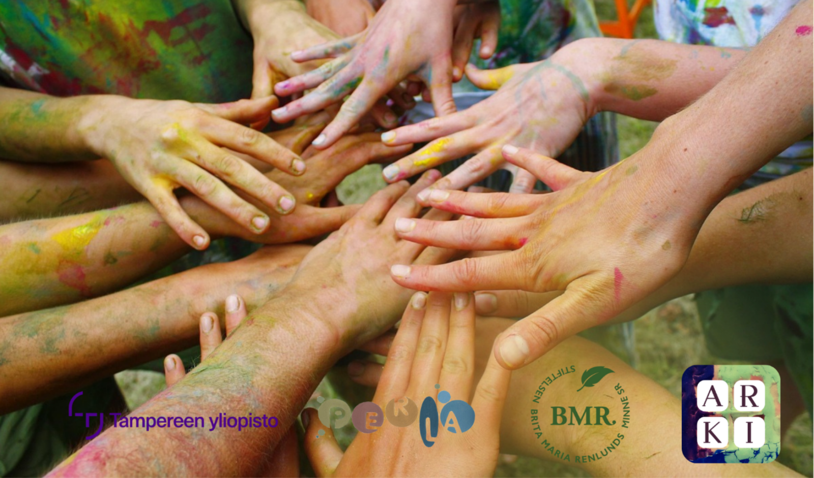 Maalisia käsiä ringissä.