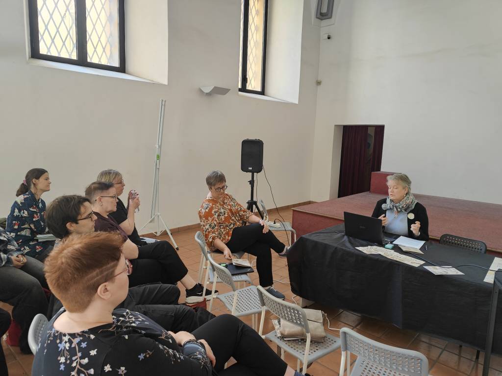 Laura Kalliomaa-Puha pitää esitelmää. Yleisön toisessa rivissä istuvat muut työpajan pitäjät: Sarjiksen tutkijat ja Outi Oja.