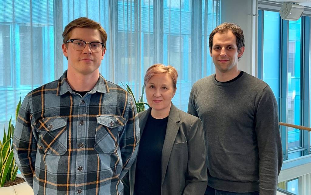 Kolme tutkijaa seisovat vierekkäin ikkunan edessä.