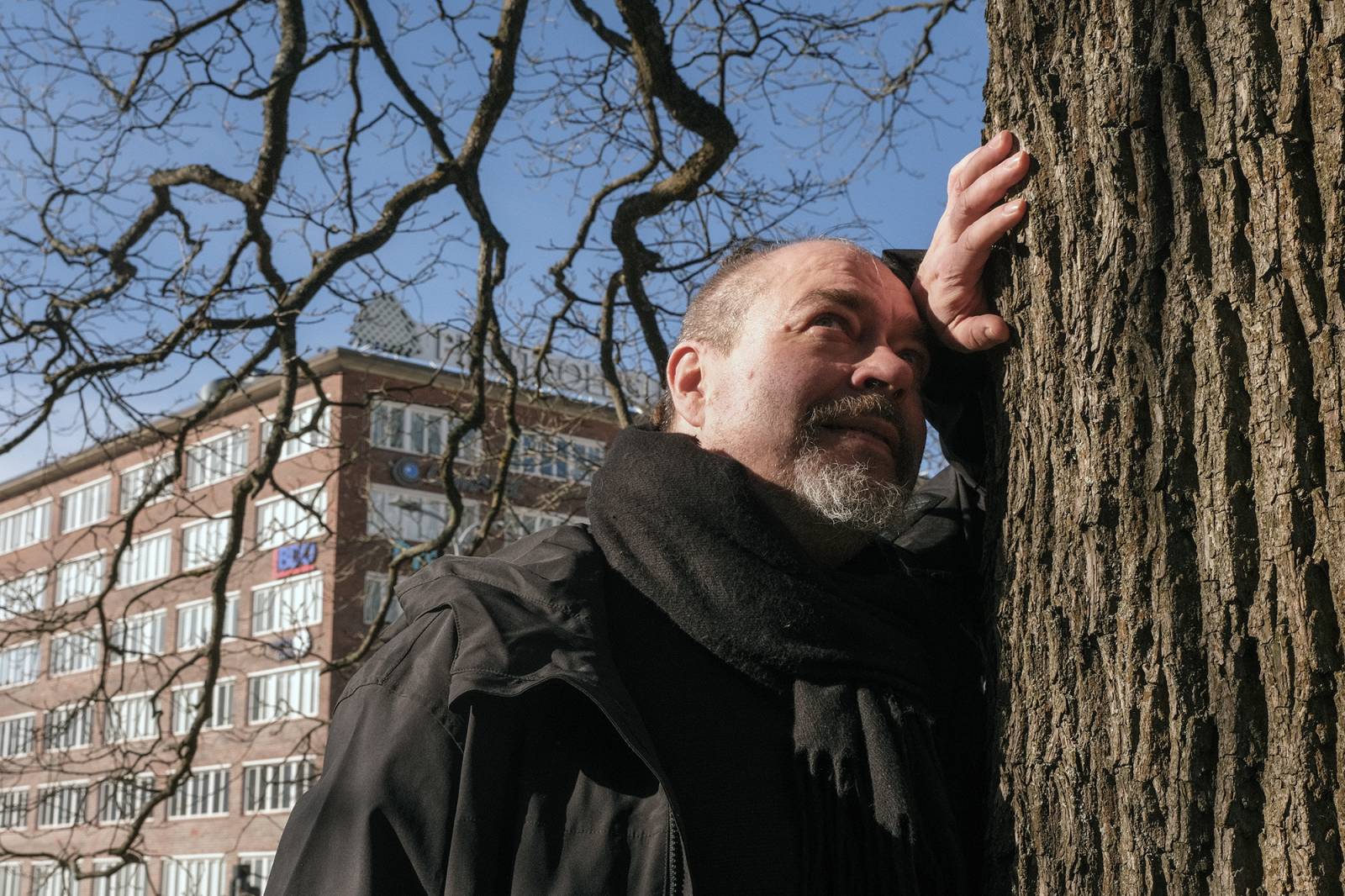 Frans Mäyrä admires the maple tree on the city centre campus and chose to be photographed beside it, inspired by J. R. R. Tolkien’s fondness for being photographed next to his favourite trees. Photo: Mira Kokko