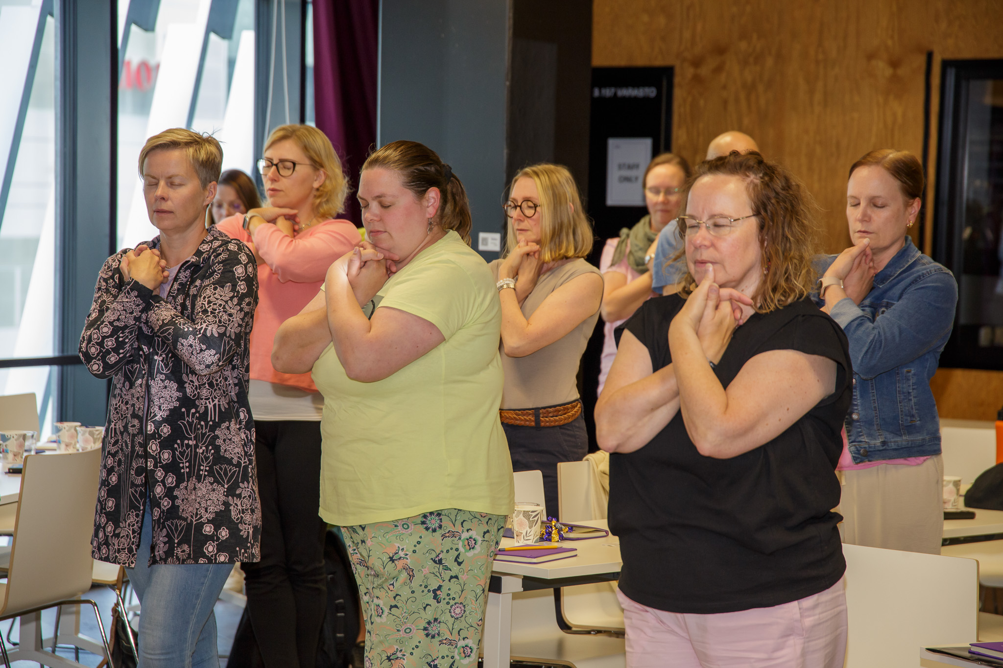 ryhmäläisiä seisomassa silmät kiinni.