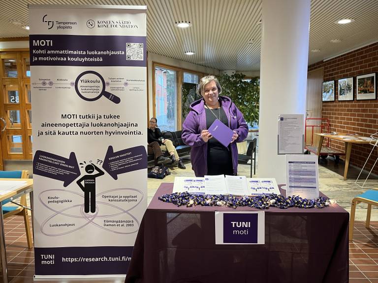 Virpi edustamassa MOTIn esittelypöudän takana Rovaniemellä kasvatustieteen päivillä.