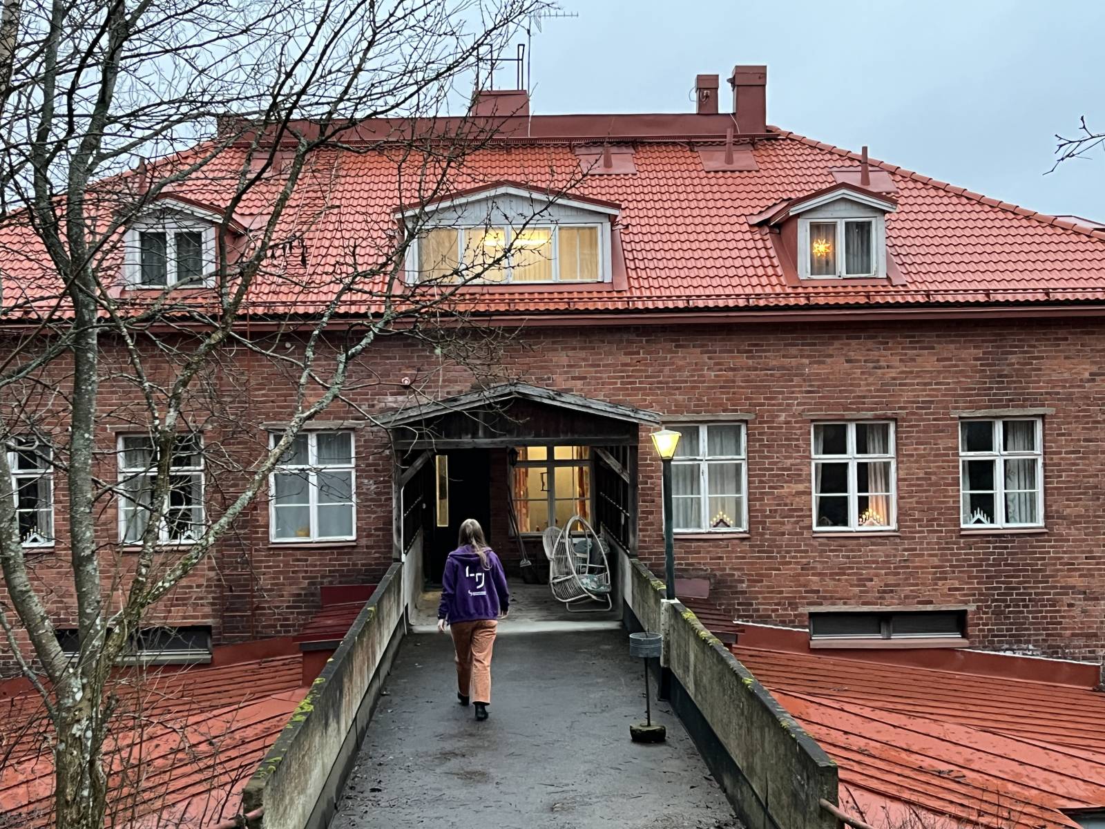 Elina kävelee kohti kivirakennusta Uotin luontaiskylpylässä