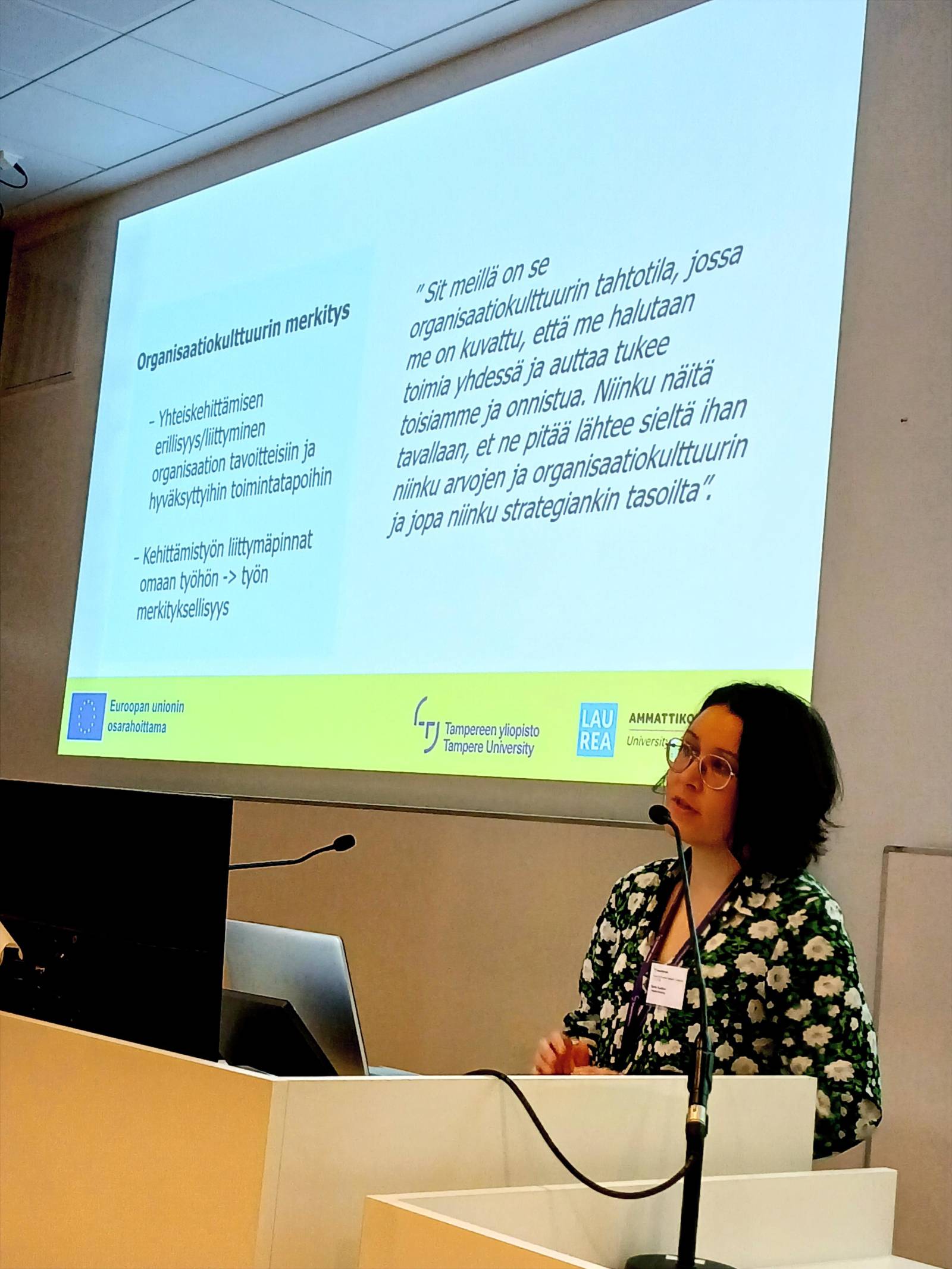 Nainen pitämässä esitelmää luentosalissa