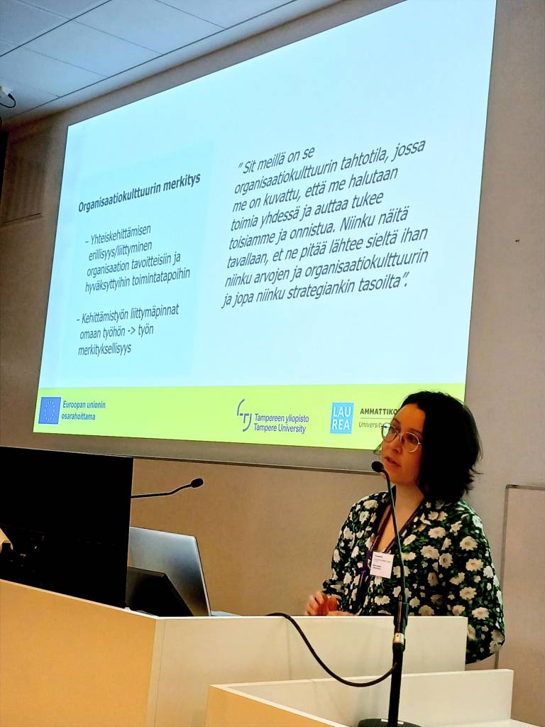 Nainen pitämässä esitelmää luentosalissa