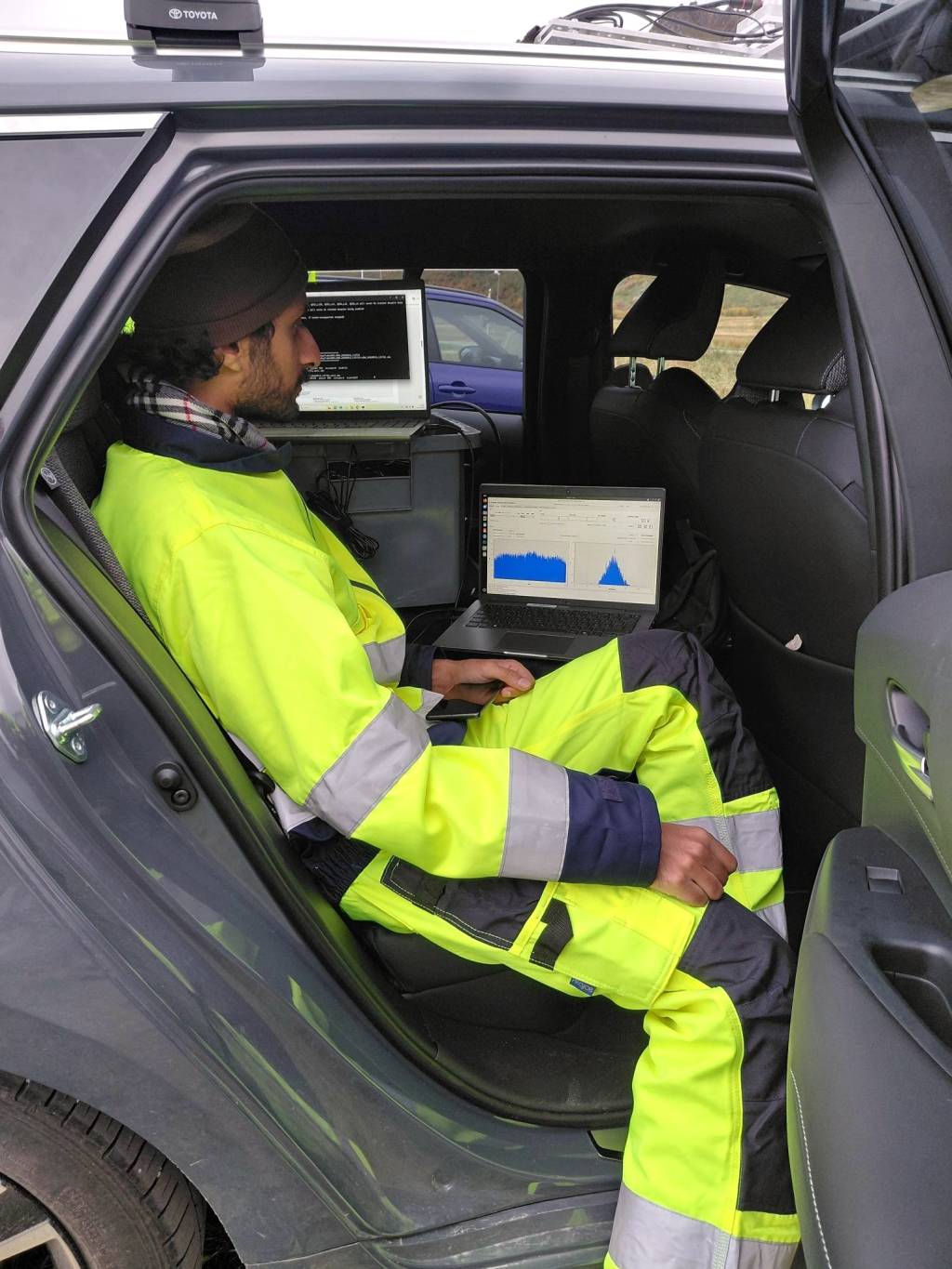 Person watching computer screens with signal visualizations.