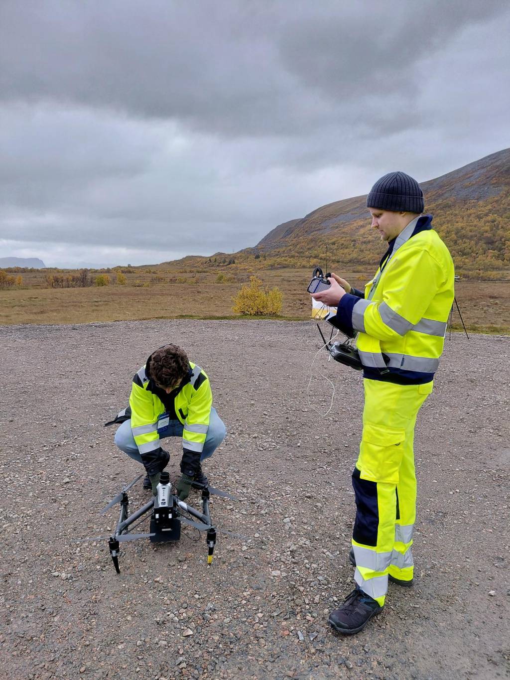 Two people setting up the drone,