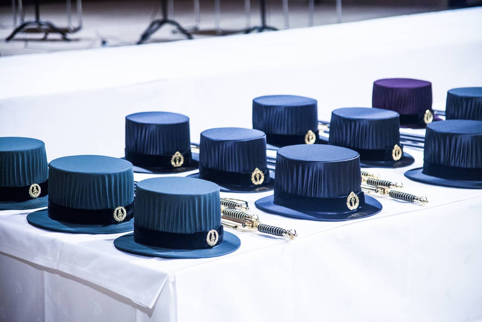 Siliter hats and swords on a white tablecloth for doctoral promotion