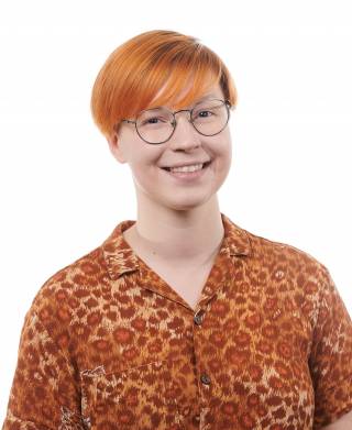 A smiling young woman with orange hair.