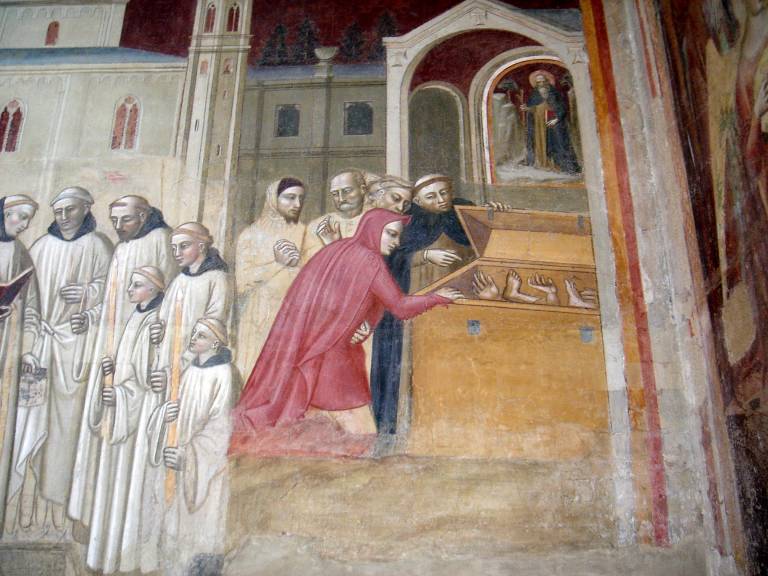 Kuvassa joukko kirkonmiehiä avaa puisen arkun, jossa näkyy käsiä ja jalkoja.