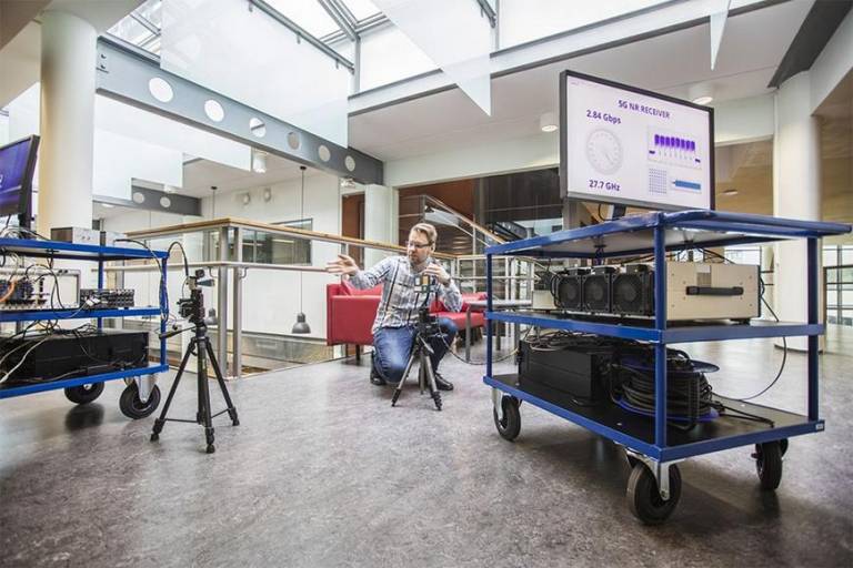 Researcher close to movable equipment utilized in wireless research related to 5G and 6G