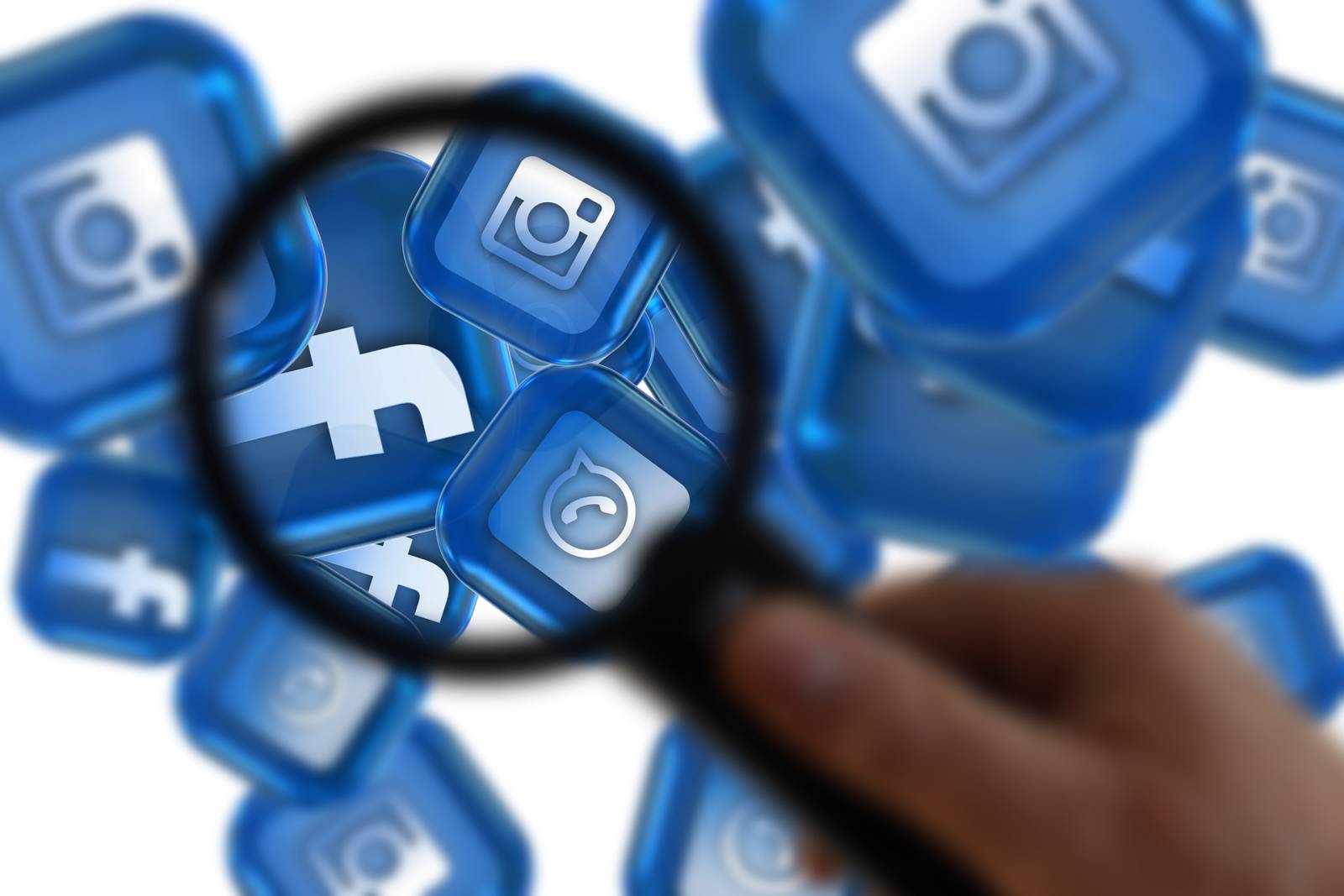 Suurennuslasin alla näkyy sosiaalisen median palvelujen logoja (Instagram, Whatsapp, Facebook)