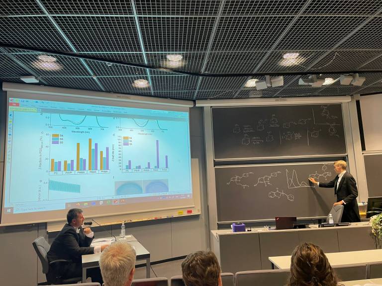 Dr. Kim Kuntze answering to his opponent's questionwriting chemical reaction mechanism on the black board during his PhD defense. His opponent, Priv.doz. Zbigniew Pianowski, is attentively listening to the answer.