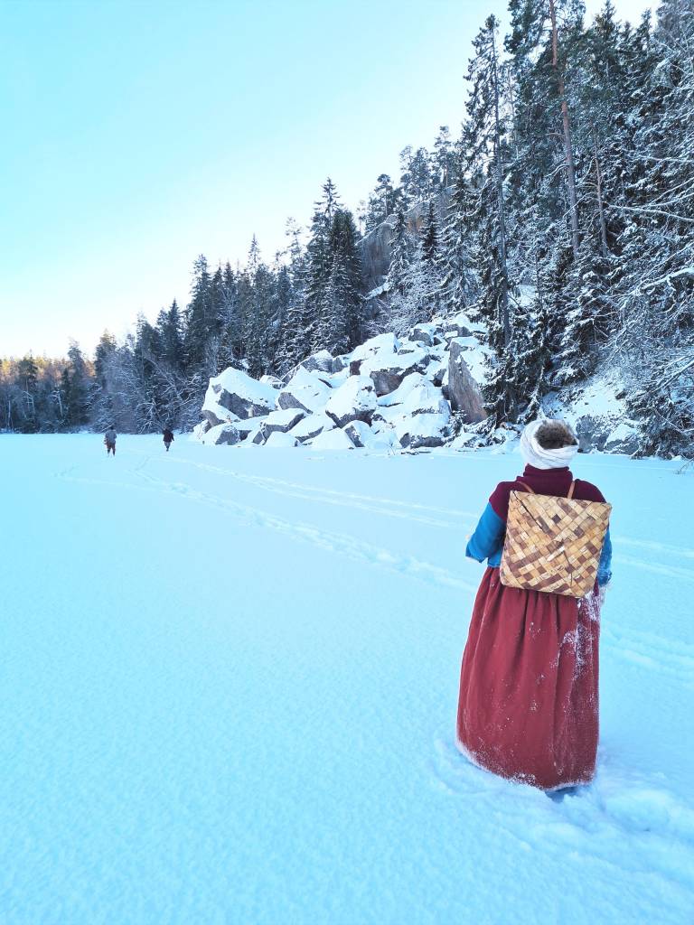 Kävelijöitä lumisessa maisemassa