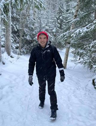 Zixuan Deng hiking in a snowy forest