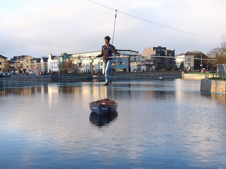 A person crossing a river on a wire.