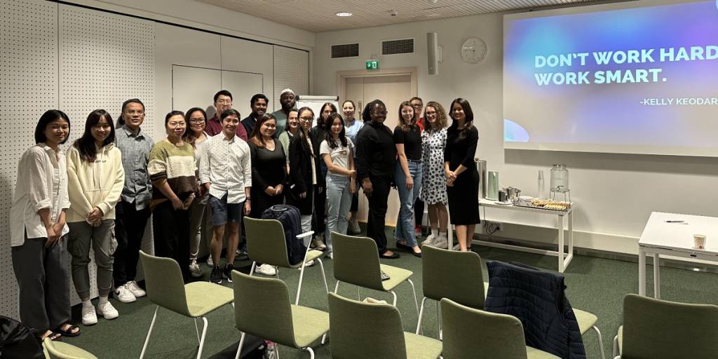 Participants of a seminar posing for a photo along the text "don't work hard, work smart"