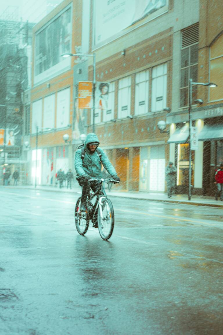 Cyclist biking in rainy city.