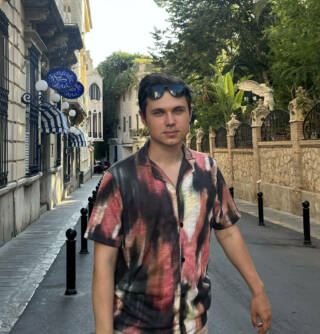Artem Boichuk outside in summer shirt on a street.