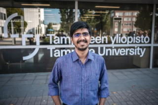 Photo of Ayush Kumar in front of Tampere University wall. Photo by ITC faculty.